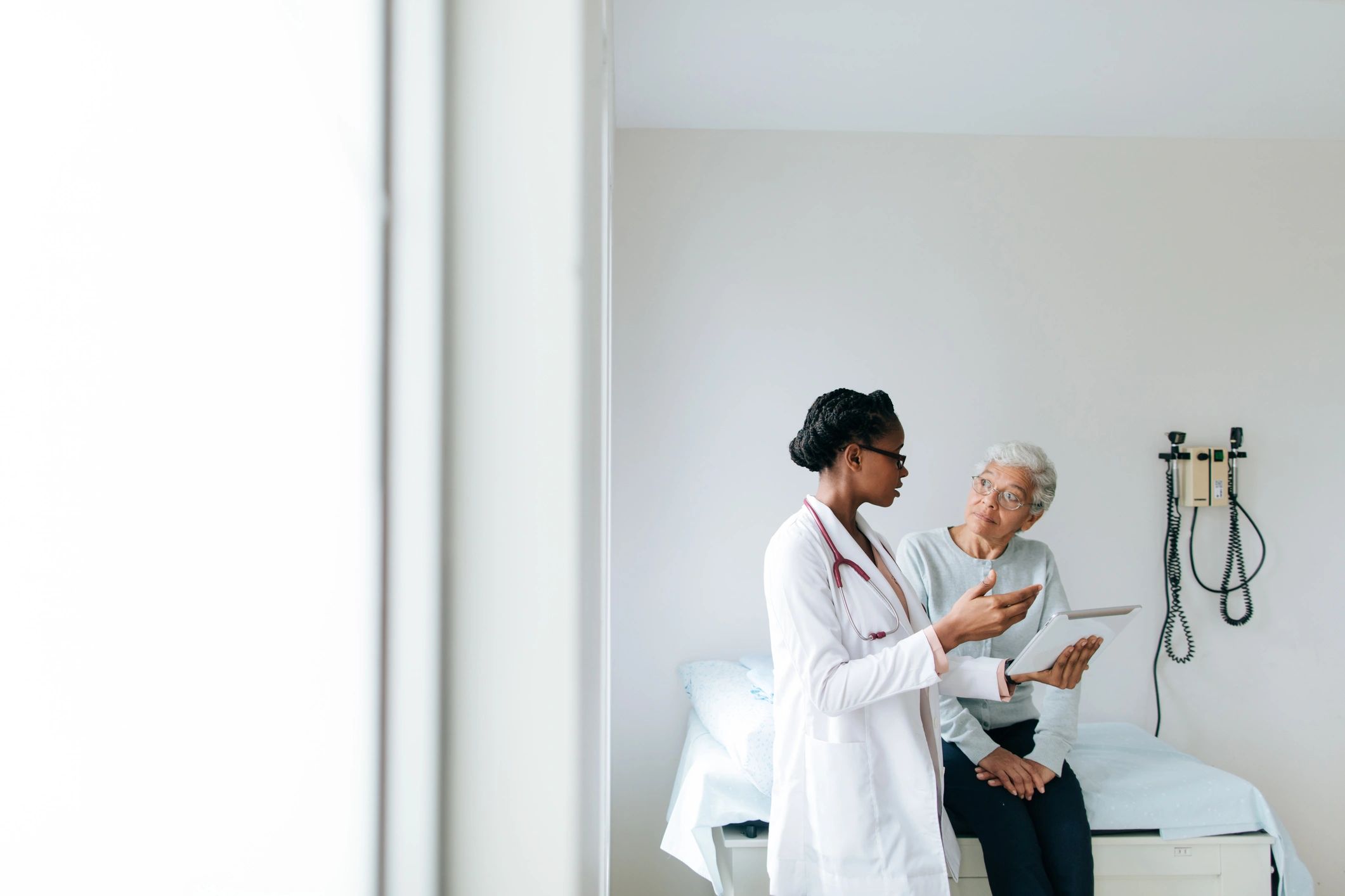 Doctor reviewing care information with a patient in an exam room