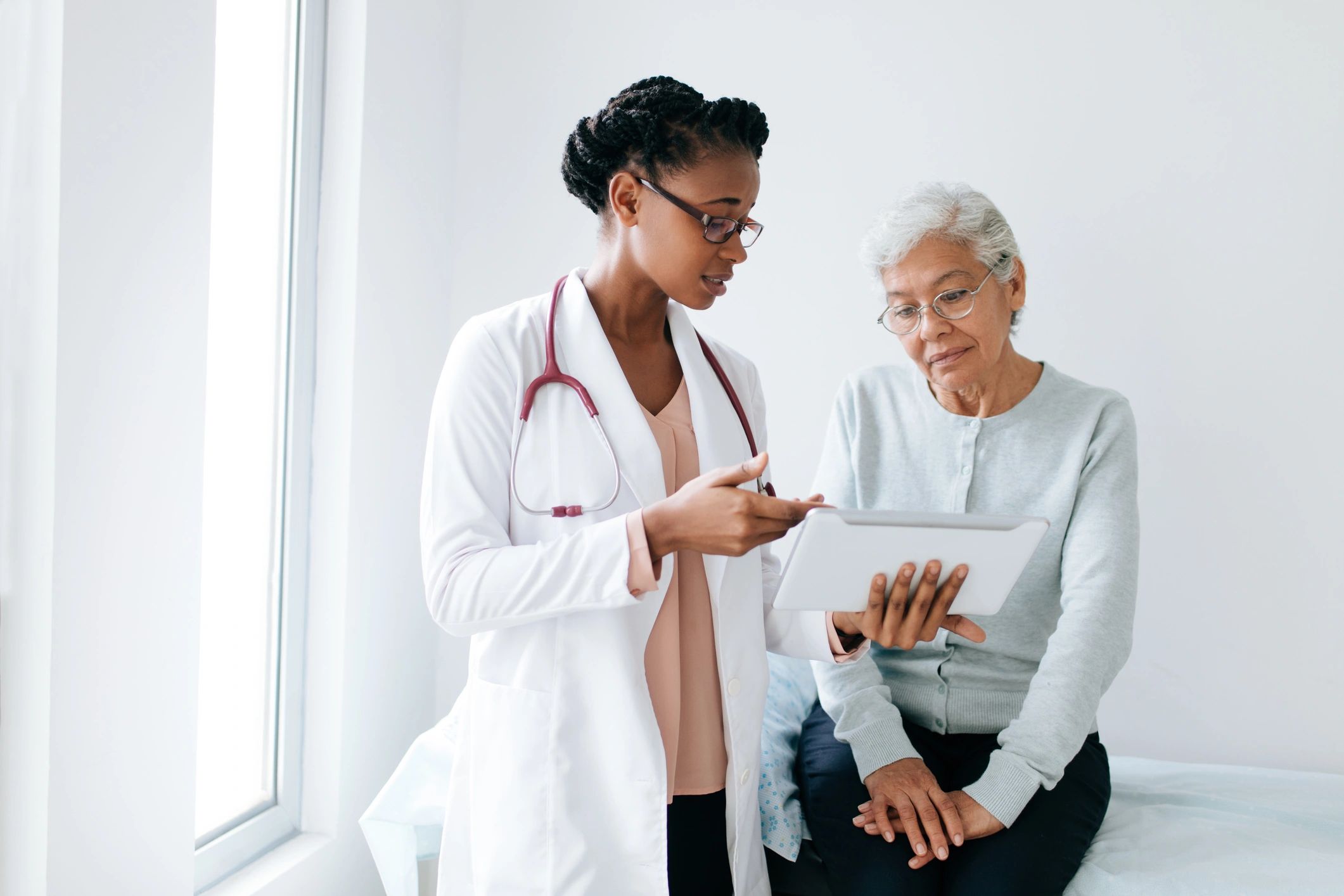 Doctor sharing health information with a patient on a tablet