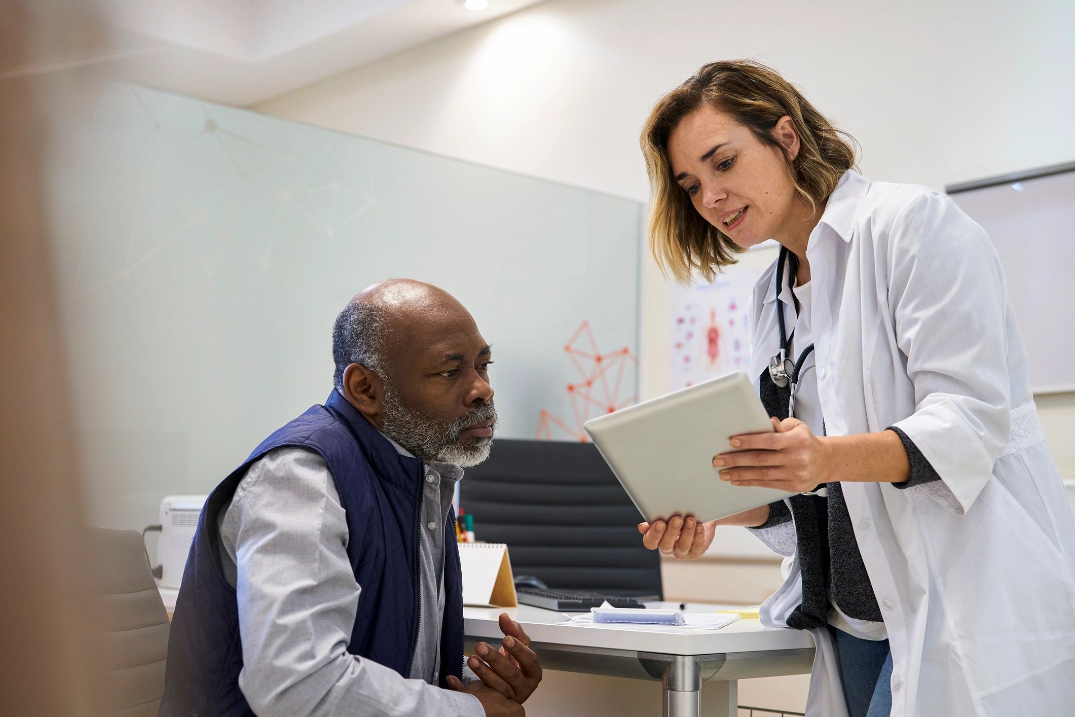 Doctor reviewing treatment information with a patient on a tablet