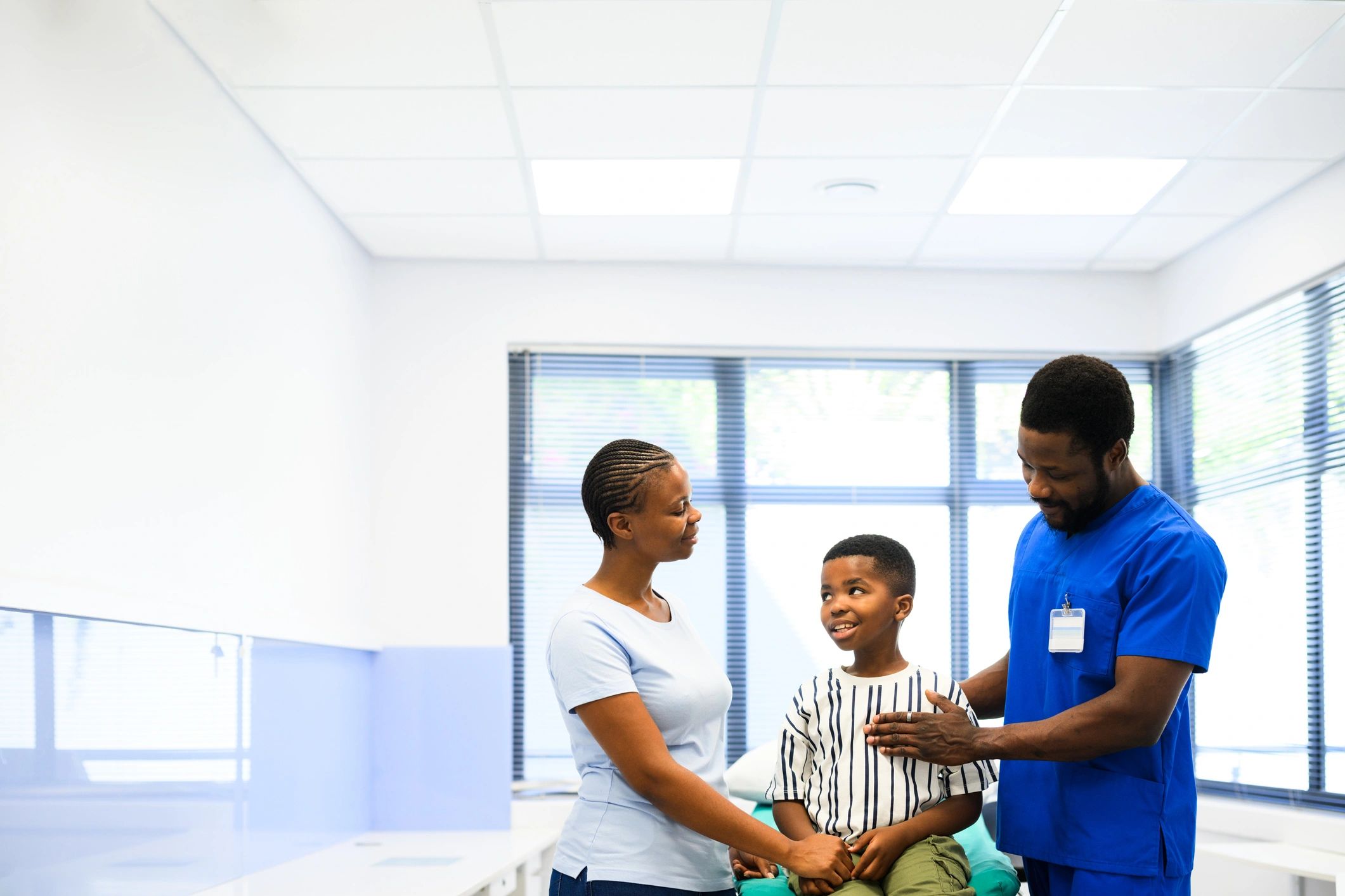 Mother with child talking to doctor in examination room